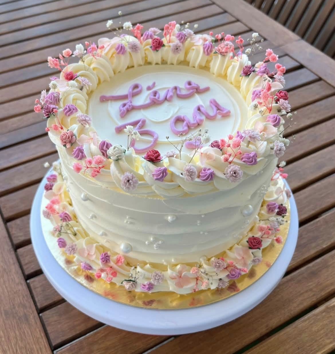 Gâteau d'anniversaire fleuri aux tons rose et ivoire